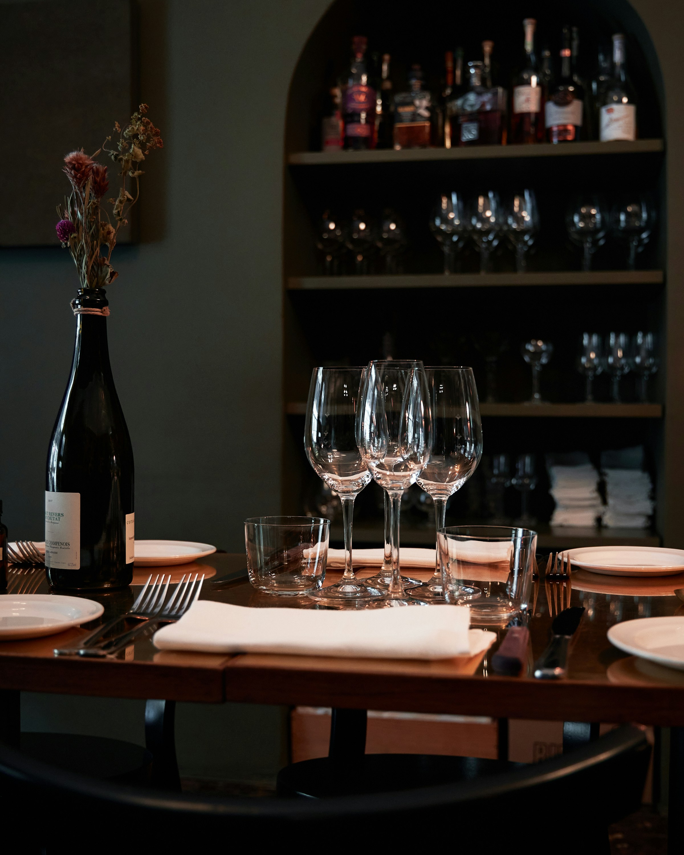 A restaurant table set with wine glasses and plates