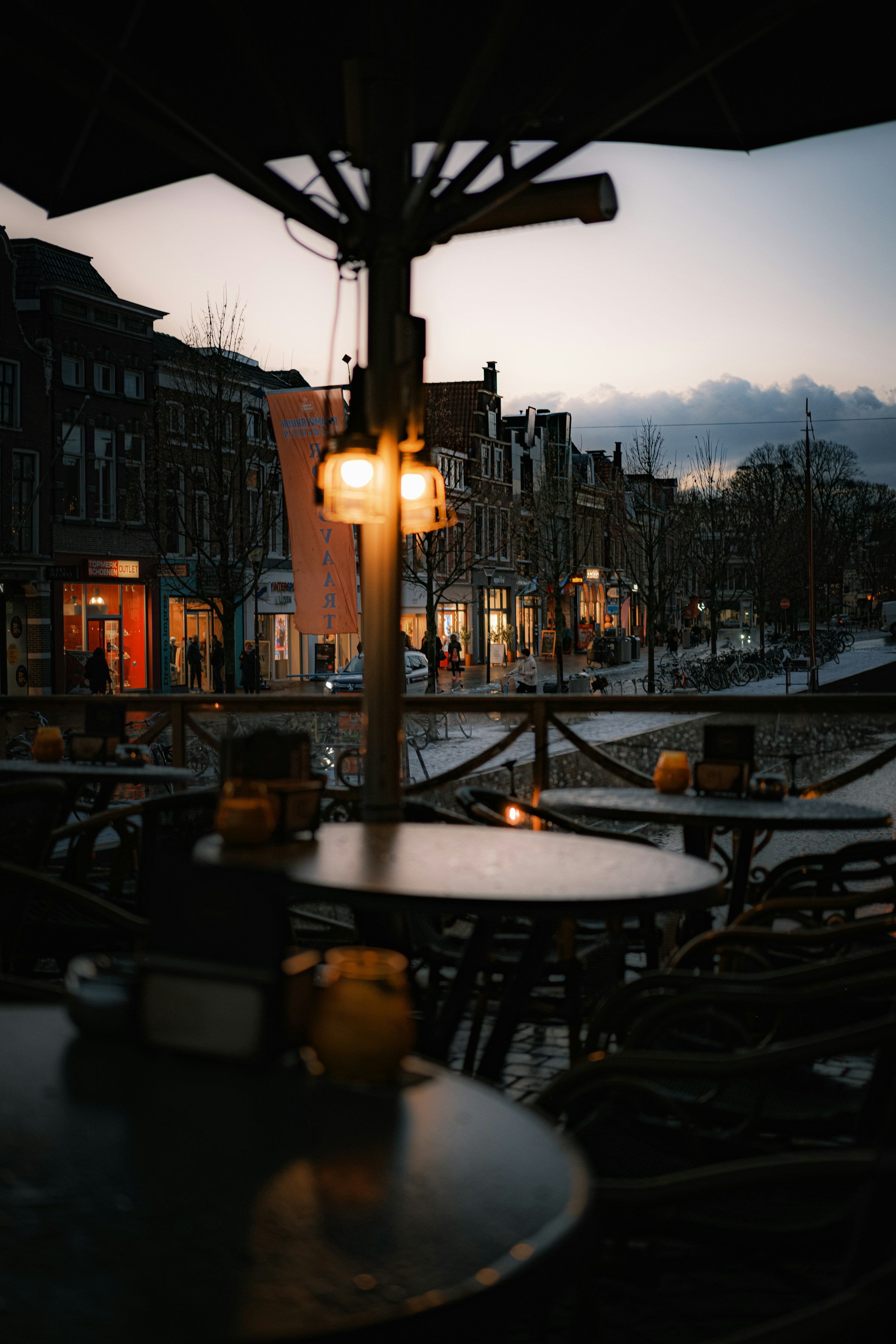 A dusk street view from inside a restaurant